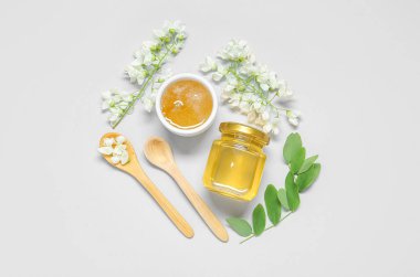 Beyaz arka planda tatlı bal ve akasya çiçekli kompozisyon