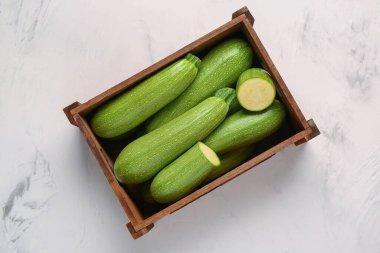 Beyaz arka planda yeşil kabaklı ahşap kutu.