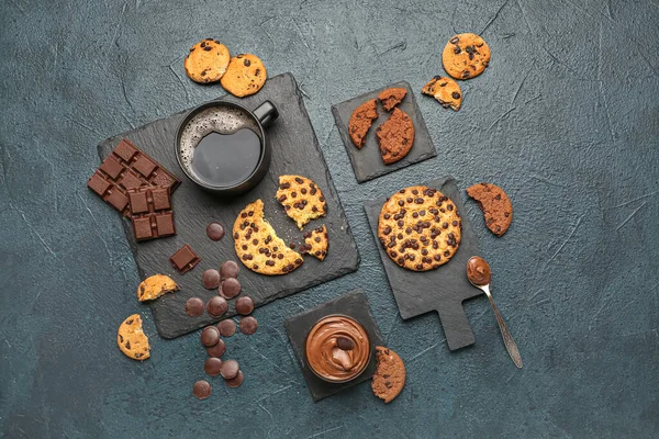 Cup of coffee with cookies, chocolate and boards on dark table