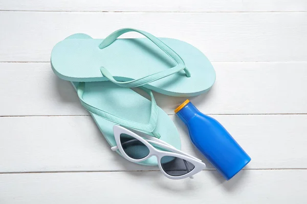 Bottle Sunscreen Cream Sunglasses Flip Flops Light Wooden Background — Stock Photo, Image