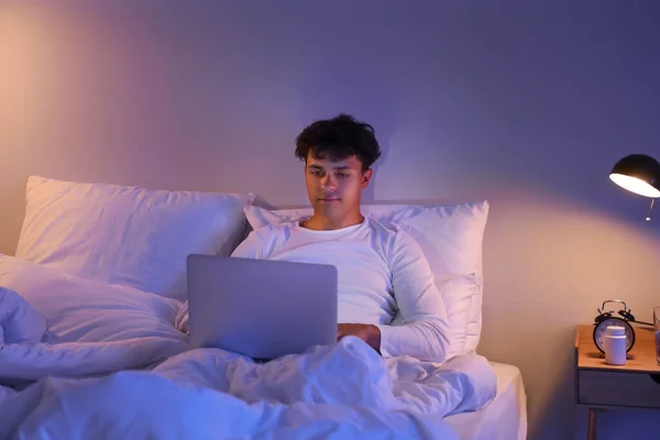 Młody Człowiek Korzystający Nocy Laptopa Łóżku — Zdjęcie stockowe