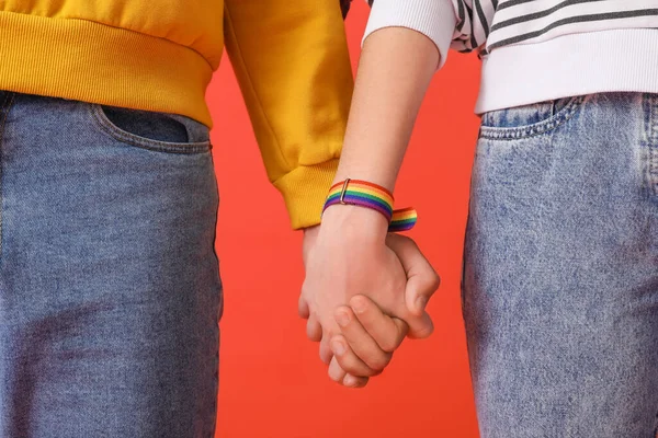 Junges Paar Mit Lgbt Armband Händchen Haltend Auf Rotem Hintergrund — Stockfoto