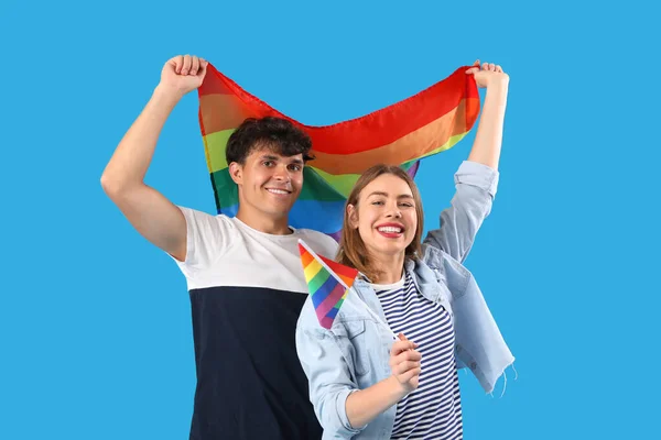 青い背景にLgbtの旗を持つ幸せな若いカップル — ストック写真