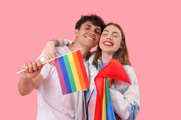ピンクを背景にしたLgbtの旗を持つ若いカップル — ストック写真