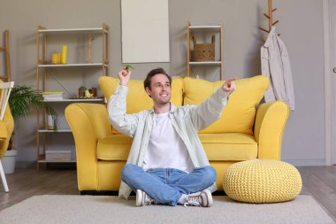 Genç adam eve kağıt uçak fırlatıyor.