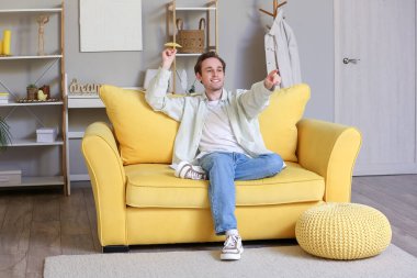 Genç adam eve kağıt uçak fırlatıyor.