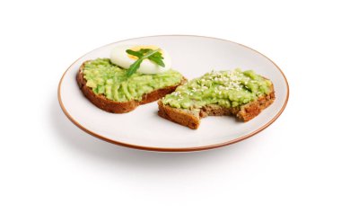 Beyaz zemin üzerinde lezzetli avokado tostları tabağı