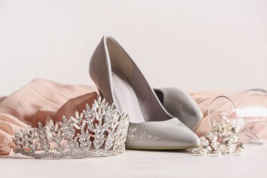 Topuklu güzel bir taç ve balo elbisesi beyaz masada, yakın plan.