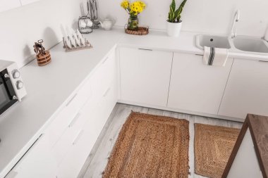 Mutfağın iç tarafında yerde hasır bir halı.