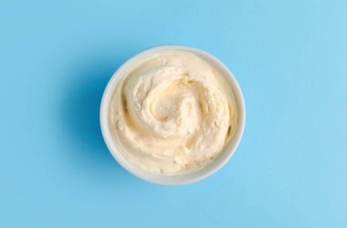 Mavi arka planda lezzetli krem peynirli kase