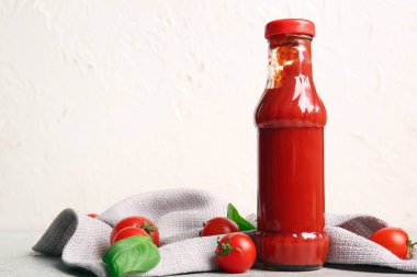 Beyaz arka planda bir şişe ketçap ve domates.