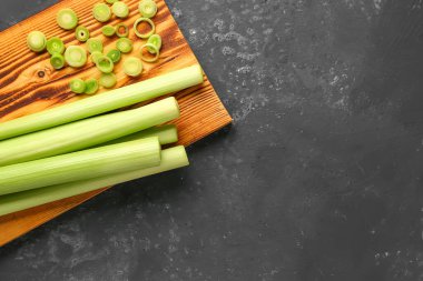 Koyu arkaplanda taze pırasa olan tahta