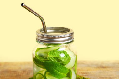 Ahşap masada salatalık dilimleri ile doldurulmuş Mason kavanozu.