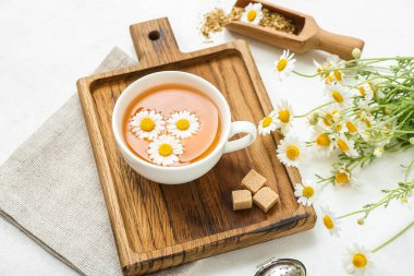 Hafif arkaplanda bir fincan sıcak papatya çayı