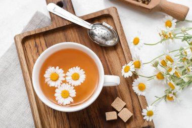 Hafif arkaplanda bir fincan sıcak papatya çayı