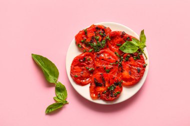 Lezzetli ızgara domates ve pembe arka planda fesleğen.