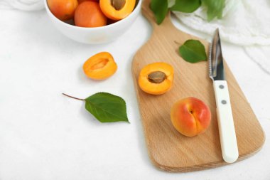 Beyaz arka planda taze kayısıları olan yemek ve kase.