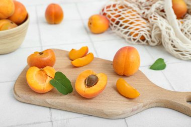 Beyaz fayans masasında taze kayısı ve kâse.