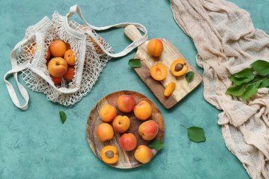 Yeşil arka planda taze kayısı ve tabak.