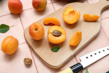 Pembe kaplama üzerinde taze kayısıları olan tahta