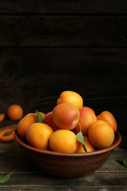 Ahşap masa üzerinde taze kayısı ile kase