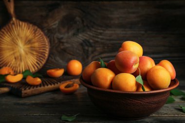 Tahta masada taze kayısılarla yemek ve kase.