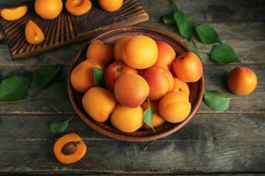 Tahta masada taze kayısılarla yemek ve kase.