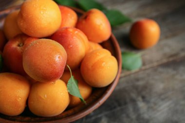 Ahşap masa üzerinde taze kayısı ile kase