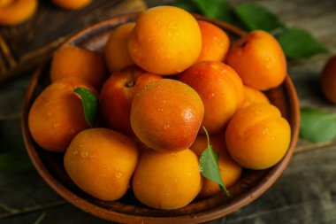 Ahşap masa üzerinde taze kayısı ile kase