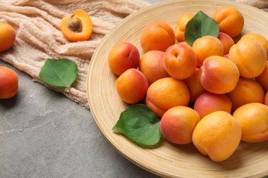 Gri arka planda taze kayısı tabağı