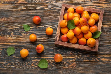 Ahşap arka planda taze kayısı kutusu