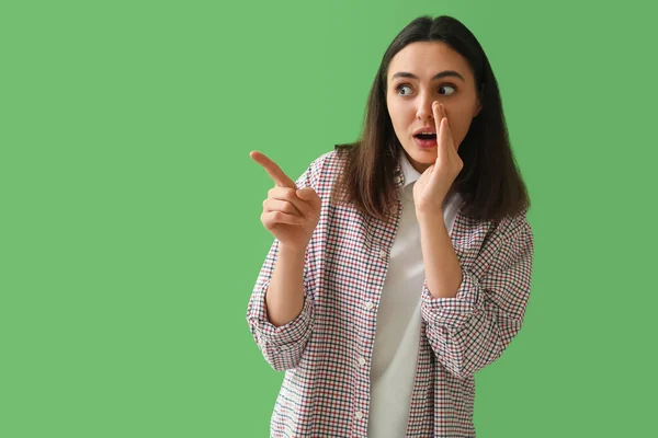 Schockierte Junge Frau Zeigt Auf Etwas Auf Grünem Hintergrund — Stockfoto