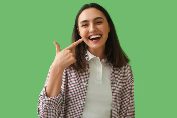 Νεαρή Γυναίκα Που Δείχνει Δόντια Της Στο Πράσινο Φόντο — Φωτογραφία Αρχείου