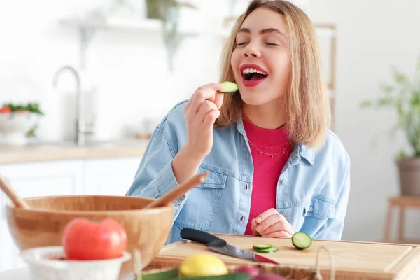 Jovem Mulher Comendo Fatia Pepino Fazer Salada Cozinha — Fotografia de Stock