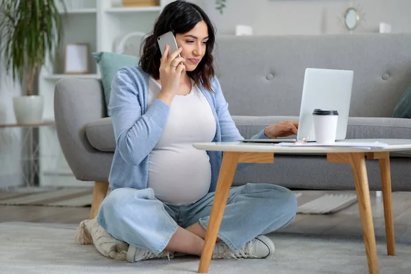 妊娠中の女性が家で携帯電話で話してる — ストック写真