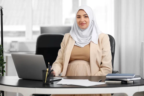若いです妊娠中のイスラム教徒の女性はオフィスでテーブルで働く — ストック写真