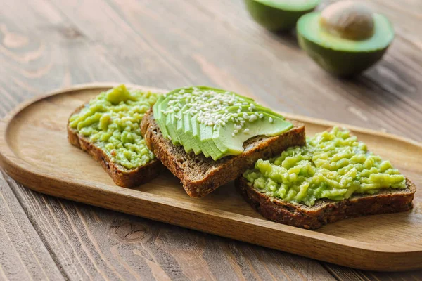 Board Tasty Avocado Toasts Wooden Background — Stock Photo, Image