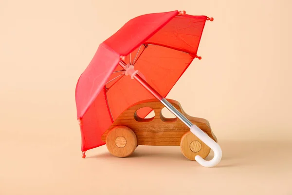 나무로 장난감 자동차와 베이지 배경에 우산으로 창의적 — 스톡 사진