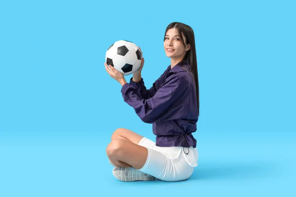 若いです女性とともにサッカーボール上の青の背景 — ストック写真