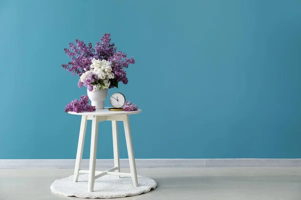 Βάζο Πασχαλινά Λουλούδια Και Ξυπνητήρι Στο Τραπέζι Κοντά Στο Μπλε — Φωτογραφία Αρχείου