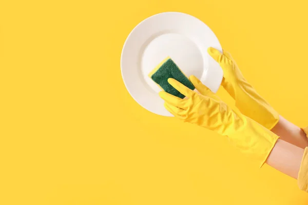 Χέρια Της Γυναίκας Πιάτο Και Σφουγγάρι Κίτρινο Φόντο — Φωτογραφία Αρχείου
