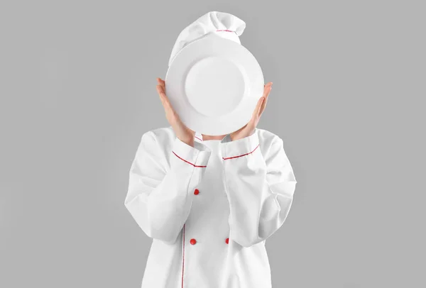 Chef Femelle Avec Plaque Vide Cachant Visage Sur Fond Gris — Photo
