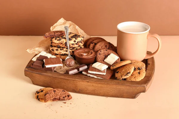 Tálca Süteményekkel Csokoládéval Csésze Tejjel Bézs Asztalon Barna Fal Mellett — Stock Fotó