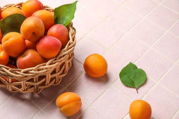 Weidenschale Mit Frischen Aprikosen Auf Rosa Fliesen Hintergrund — Stockfoto