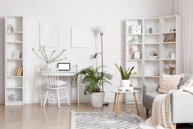 Ev bitkileriyle aydınlık oturma odasının şık bir iç mekanı.