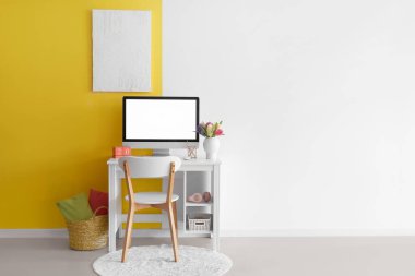 Modern bilgisayar, sümbül çiçekleri ve duvarında posteri olan rahat bir iş yeri.