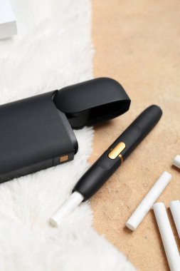 Bej masasında sopaları olan modern elektronik puro.