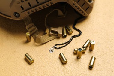 Askeri miğfer, kurşun ve zincir Ukrayna arması bej arka planda, yakın plan.