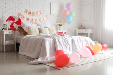 Yatak odasının içi balonlar, pinyatalar ve çelenklerle süslenmiş.