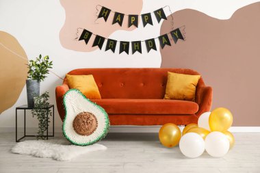 Doğum günü için dekore edilmiş oturma odasının içi pinata, balon ve çelenk ile süslenmiş.